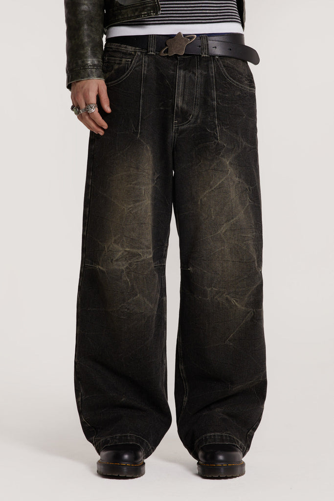 Male model wearing washed black jeans in an ultra wide leg fit. 