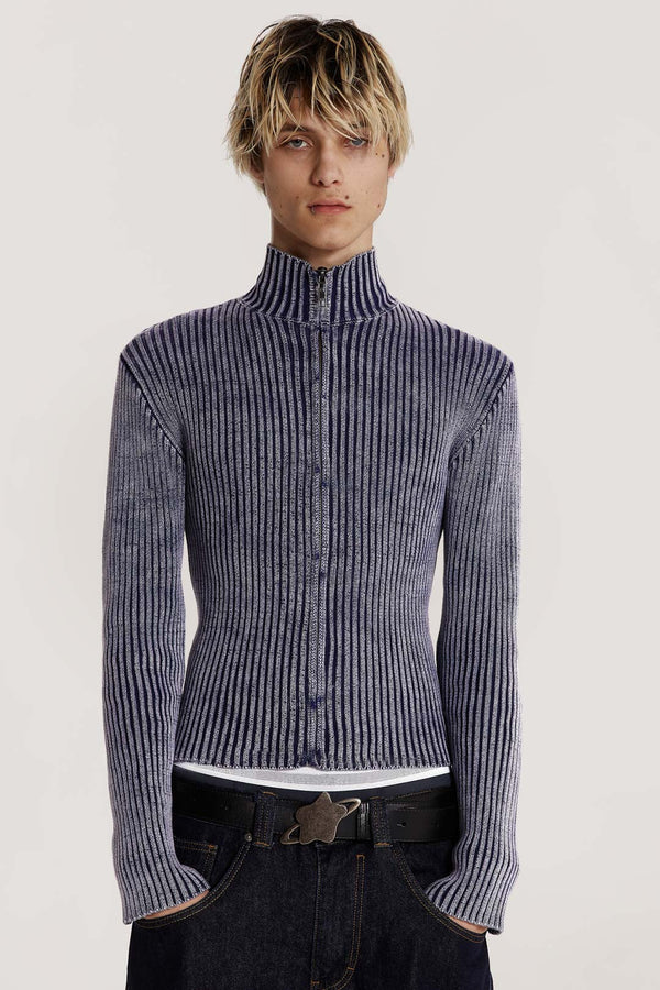 Male model wearing a blue track top crafted in a heavyweight knit with a funnel neck detail. The acid wash fabric gives the look of a washed denim material.