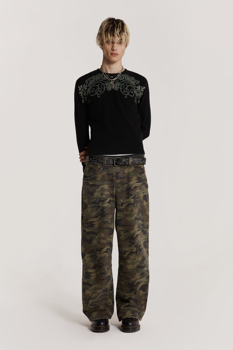  Male model wearing green camouflage print denim jeans in Colossus fit. 