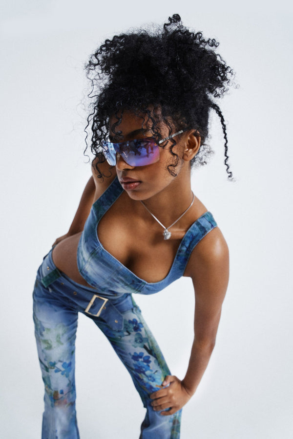Female wearing Blue Floral Denim Corset Top. Styled with the matching floral jeans.