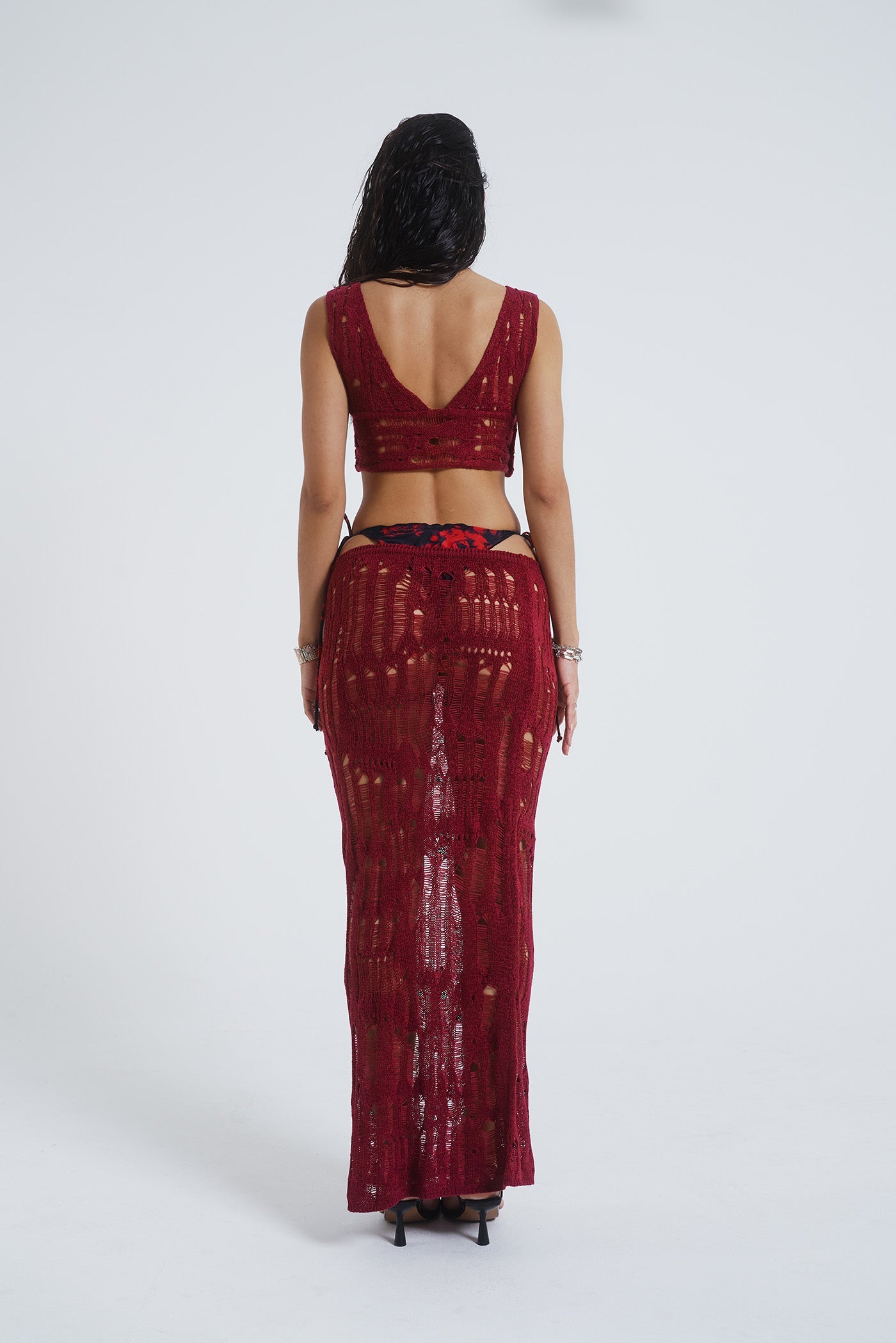 Female model wearing Burgundy Laddered Knit Wrap Around Beach Top. Paired with the matching laddered knit maxi skirt. 