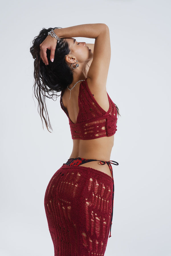 Female model wearing Burgundy Laddered Knit Wrap Around Beach Top. Paired with the matching laddered knit maxi skirt. 