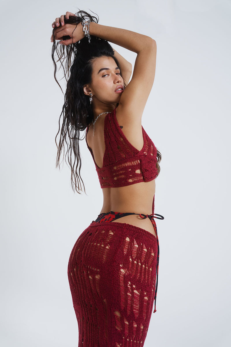 Female model wearing Burgundy Laddered Knit Wrap Around Beach Top. Paired with the matching laddered knit maxi skirt. 