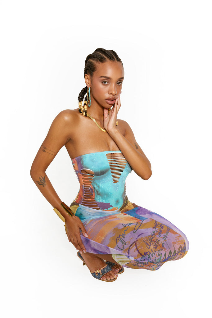Female model wearing the Statue Mix Print Mesh Column Maxi Skirt. Styled with the matching bandeau slashed swimsuit. 