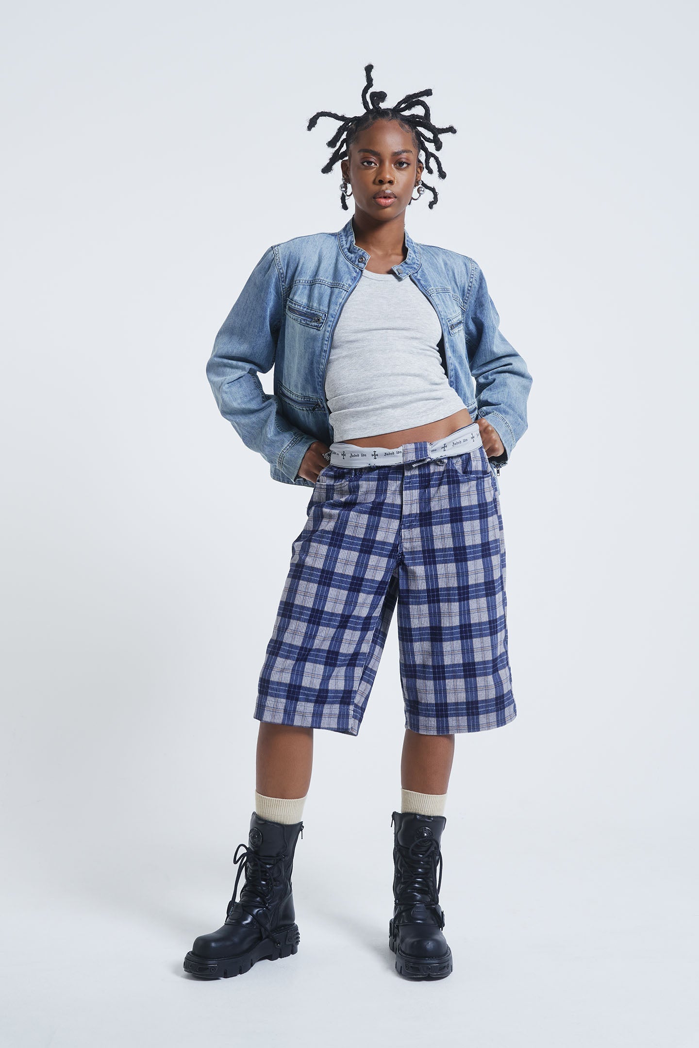 Female model wearing blue checked cord jorts in a jumbo fit. 