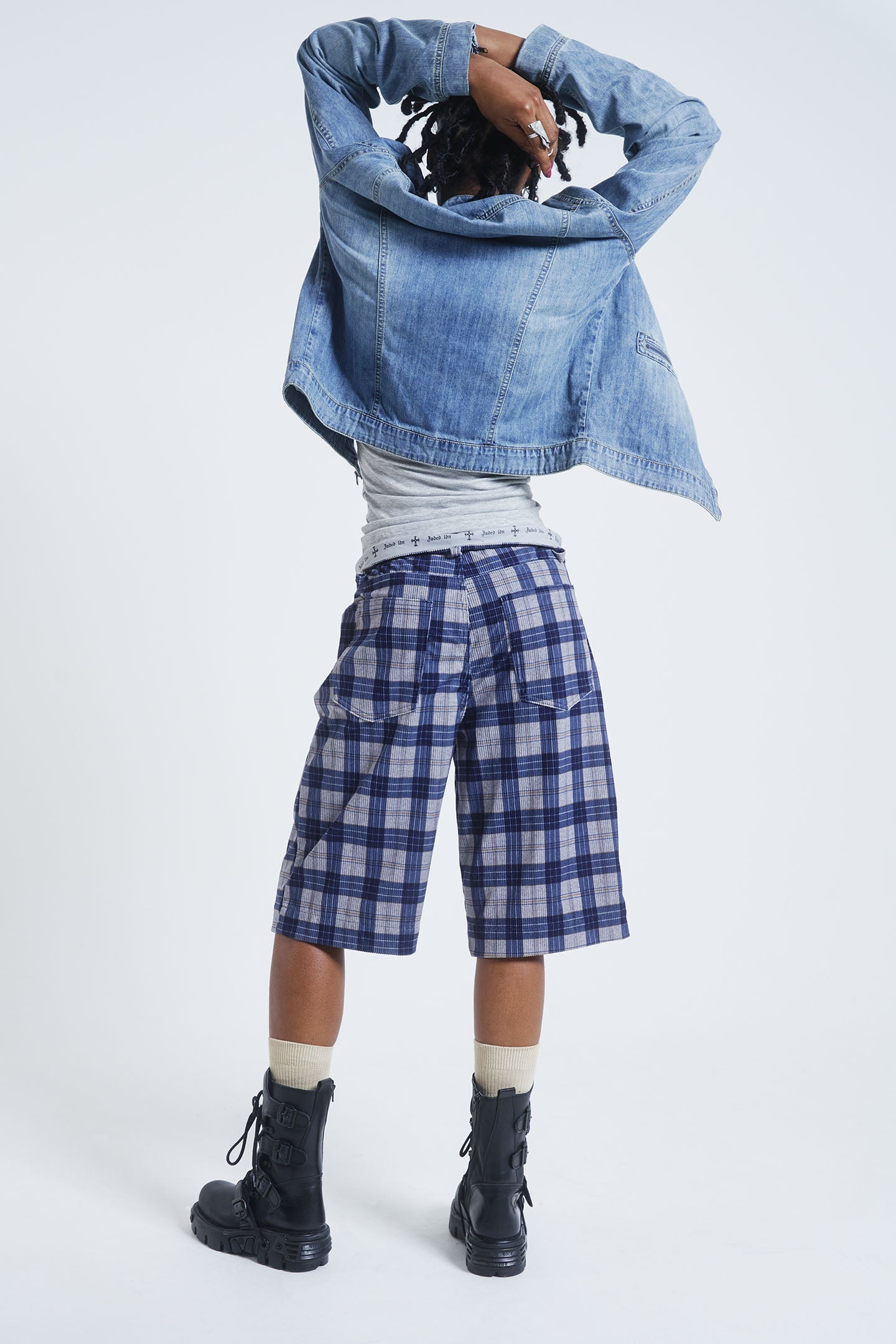 Female model wearing blue checked cord jorts in a jumbo fit. 