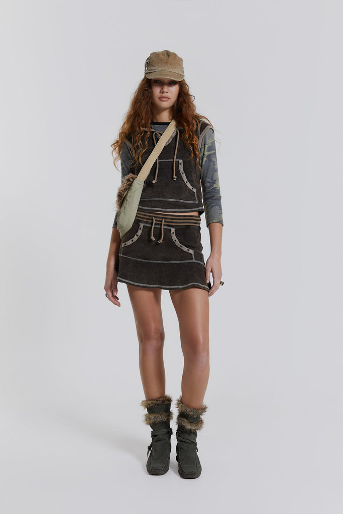 Female model wearing a washed brown cap sleeve top with kangaroo pocket, styled with the matching mini skirt. 