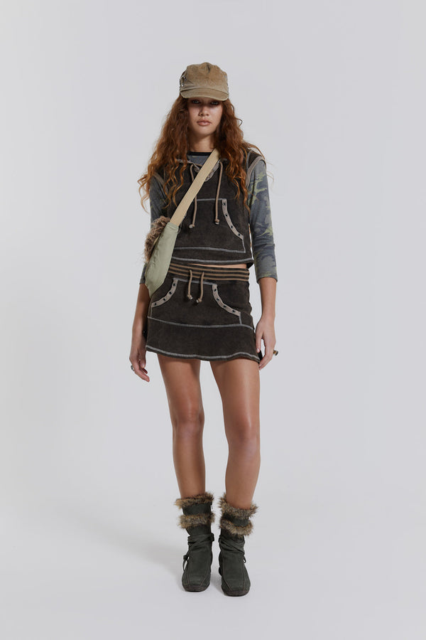 Female model wearing a washed brown sporty mini skirt with frill hem. Styled with the matching cap sleeve top. 
