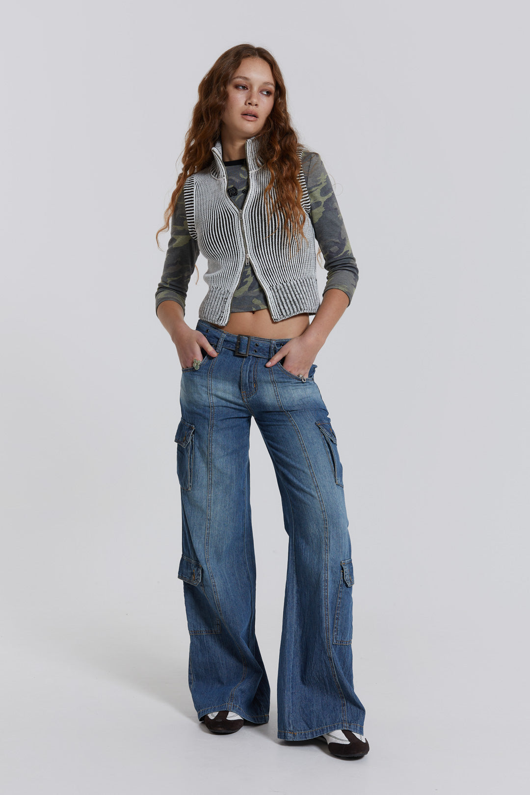 Female model wearing blue washed chambray denim skater fit jeans with belt detail. 