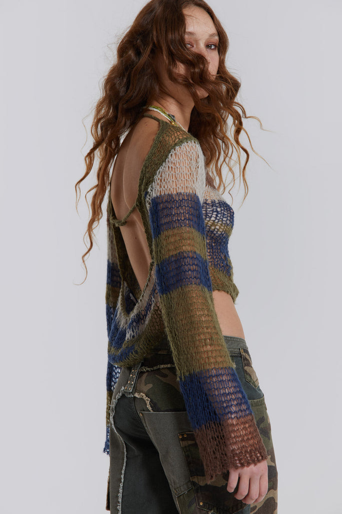 Female model wearing a green and blue abstract loose fine knit top. 