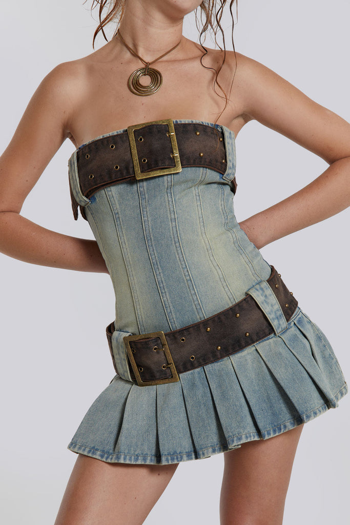 Female model wearing a blue denim pleated mini dress which features a double denim belt detail.  