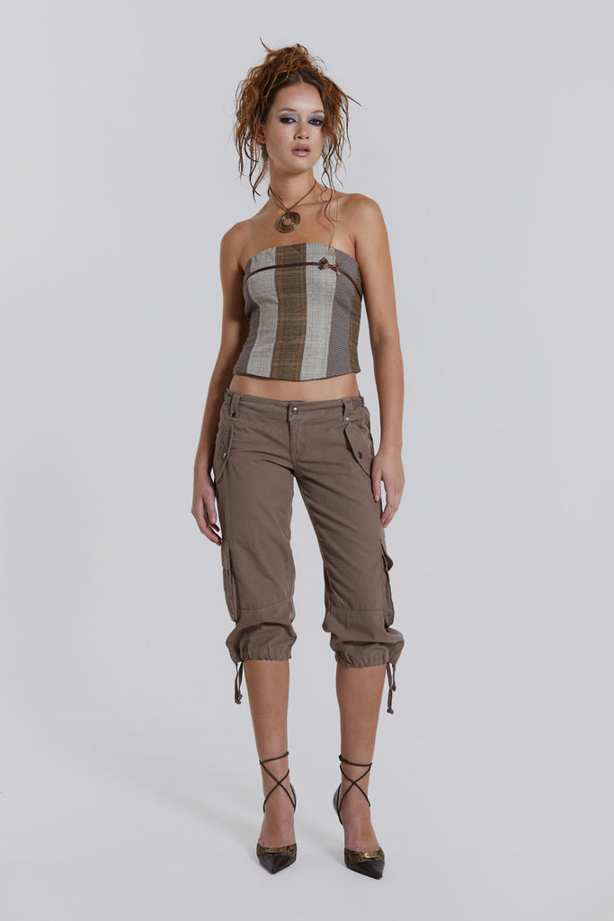 Female model wearing a panelled check corset top with a stitched ribbon detail. Styled with cropped cargo trousers. 
