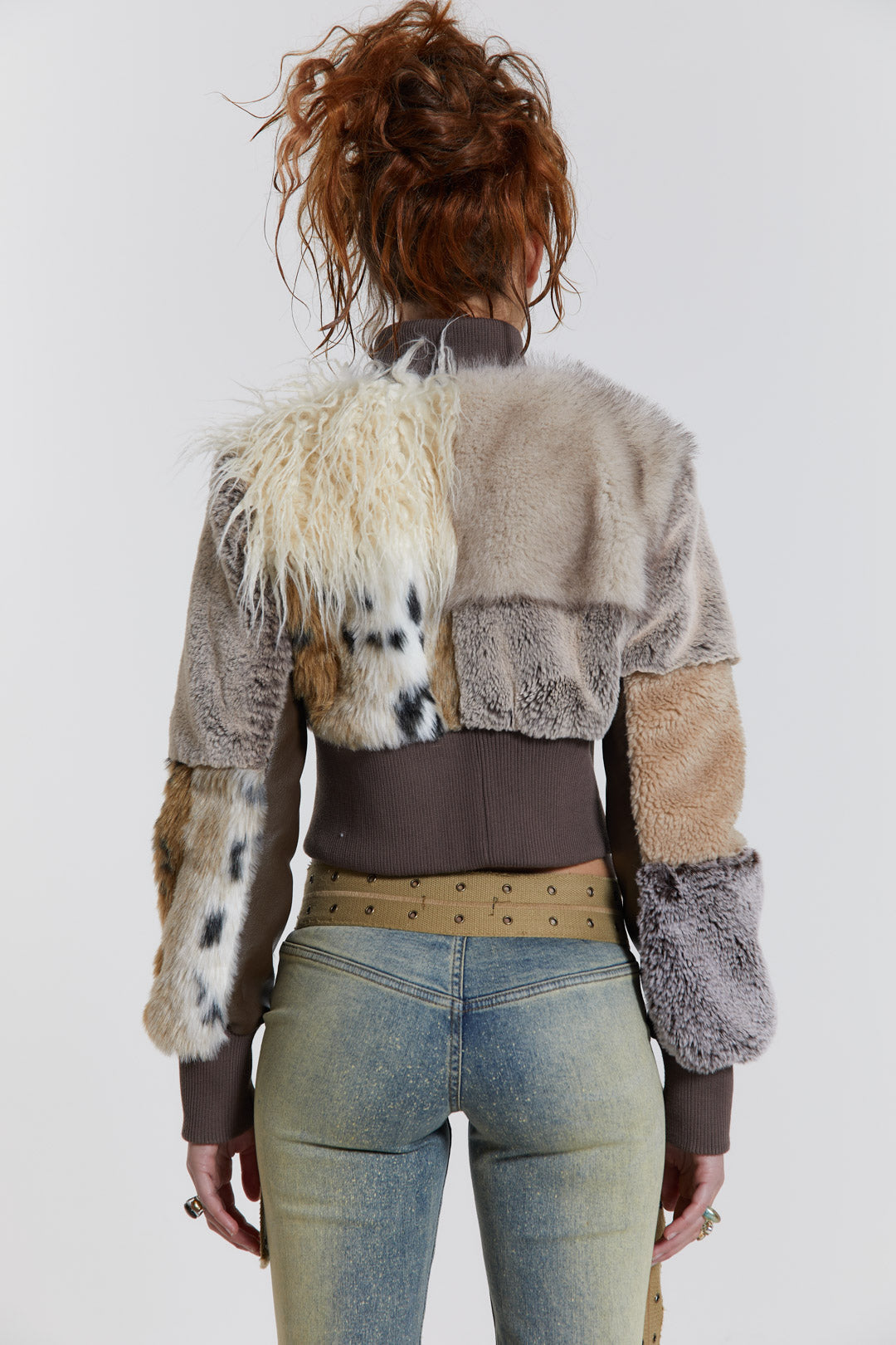 Female model wearing a patchwork faux fur bomber jacket with a ribbed collar and cuffs. 