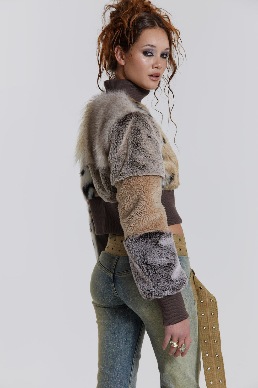 Female model wearing a patchwork faux fur bomber jacket with a ribbed collar and cuffs. 