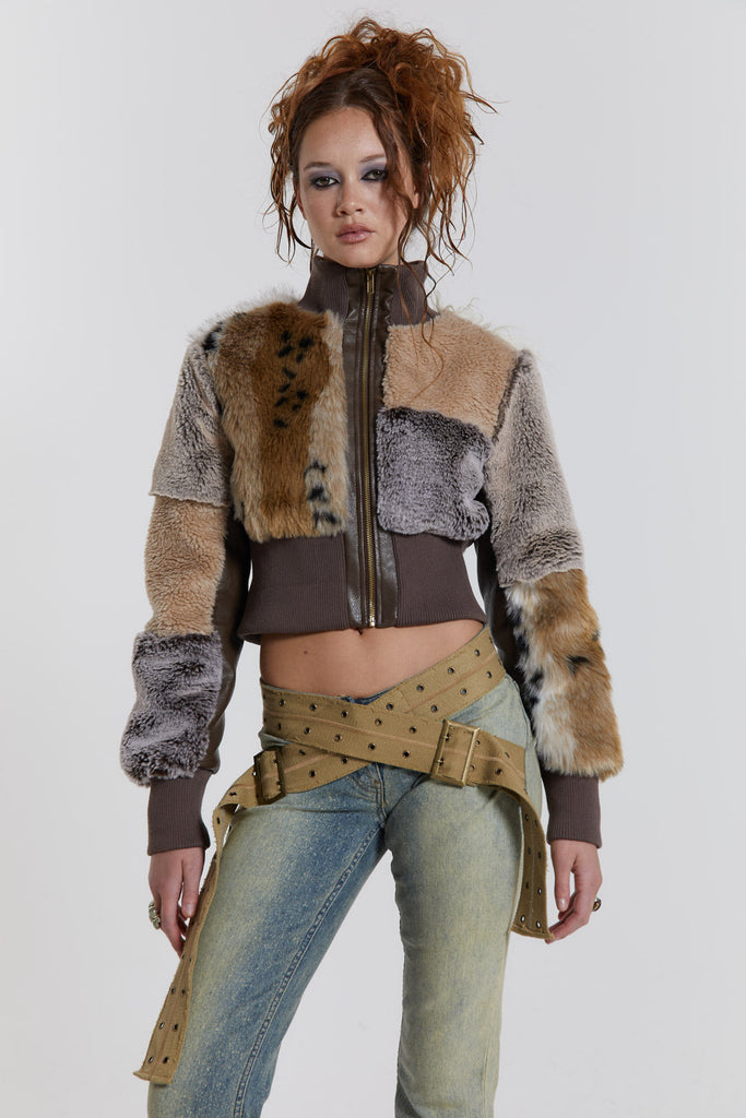 Female model wearing a patchwork faux fur bomber jacket with a ribbed collar and cuffs. 