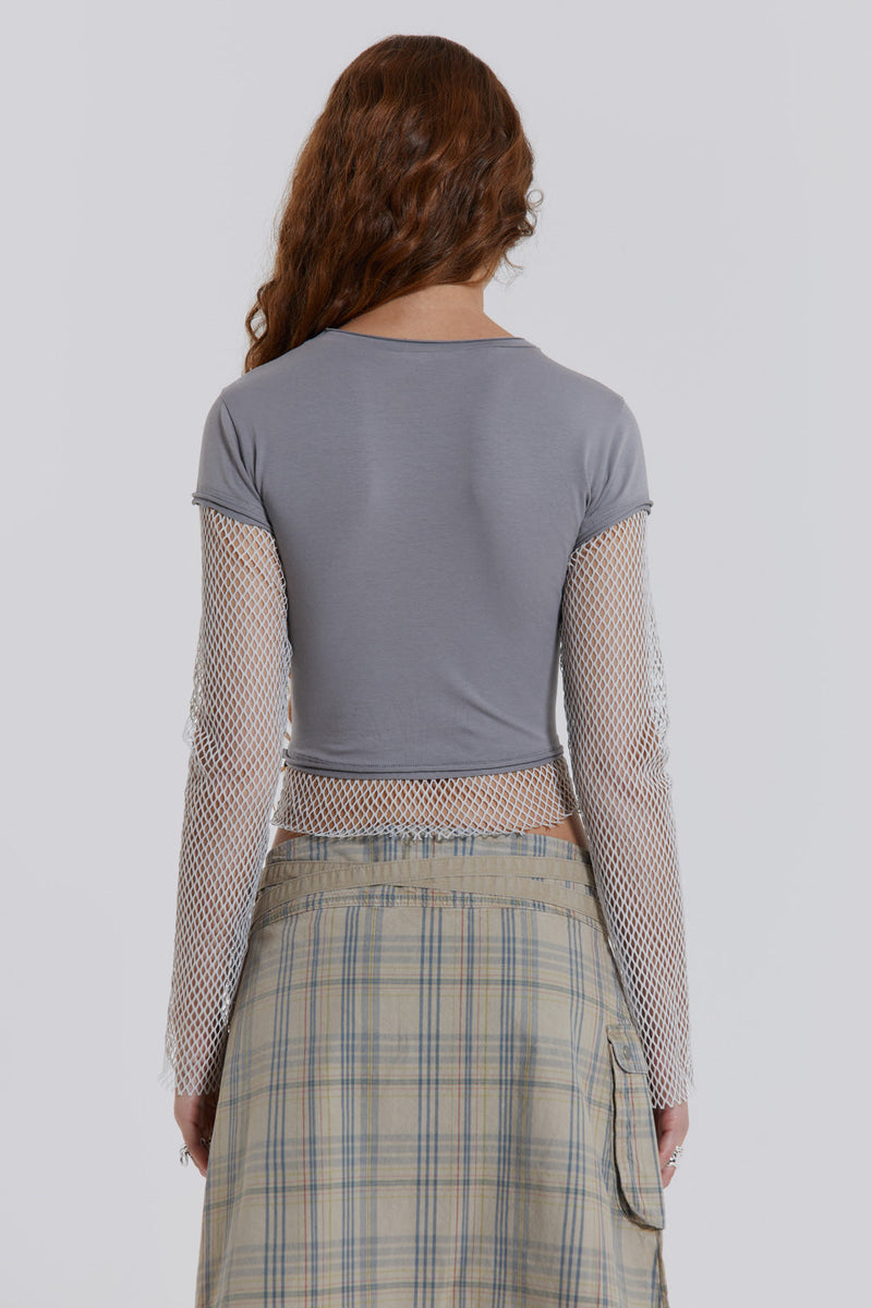 Female model wearing a grey t-shirt with long contrast mesh sleeves, styled with a check midi skirt. 