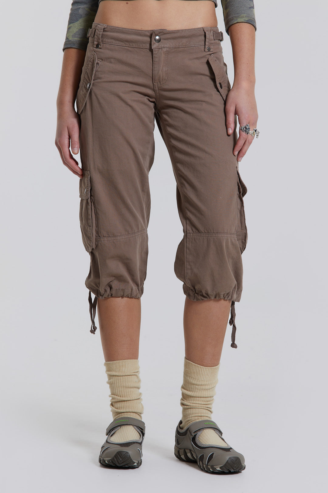 Female model wearing walnut cropped cargo trousers with a drawcord hem detail. Paired with a check corset top. 