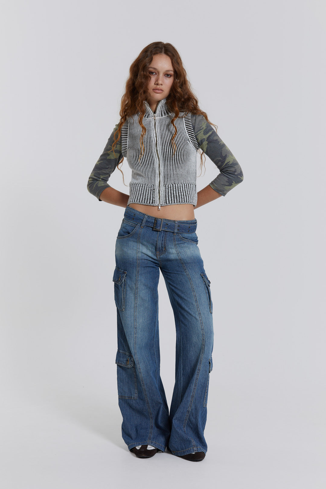 Female model wearing blue washed chambray denim skater fit jeans with belt detail. 