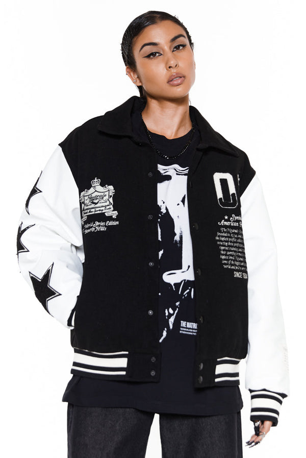 Black and white oversized varsity jacket styled with black jeans and a black and white graphic t-shirt. 