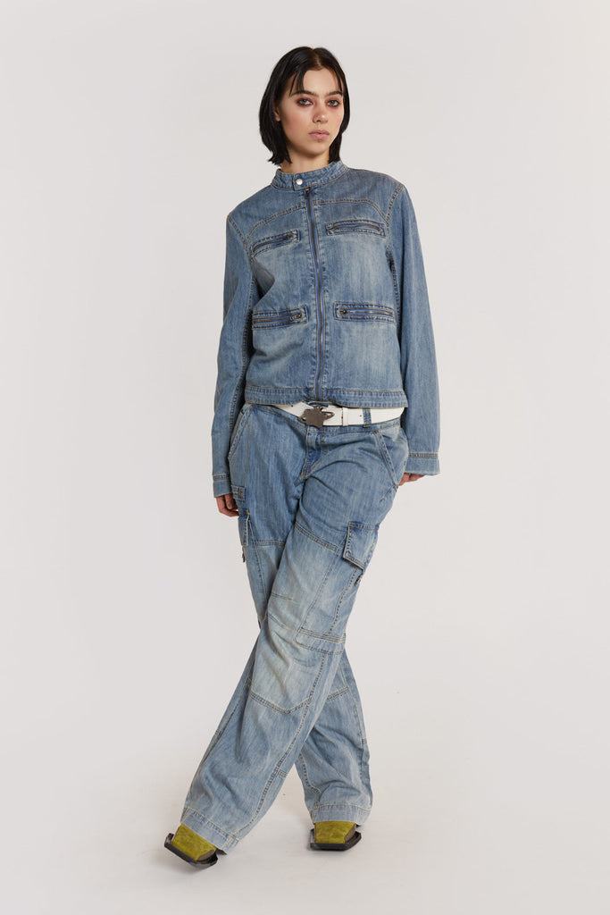 Female model wearing Chambray Denim Moto Jacket. Styled with the matching denim jeans. 