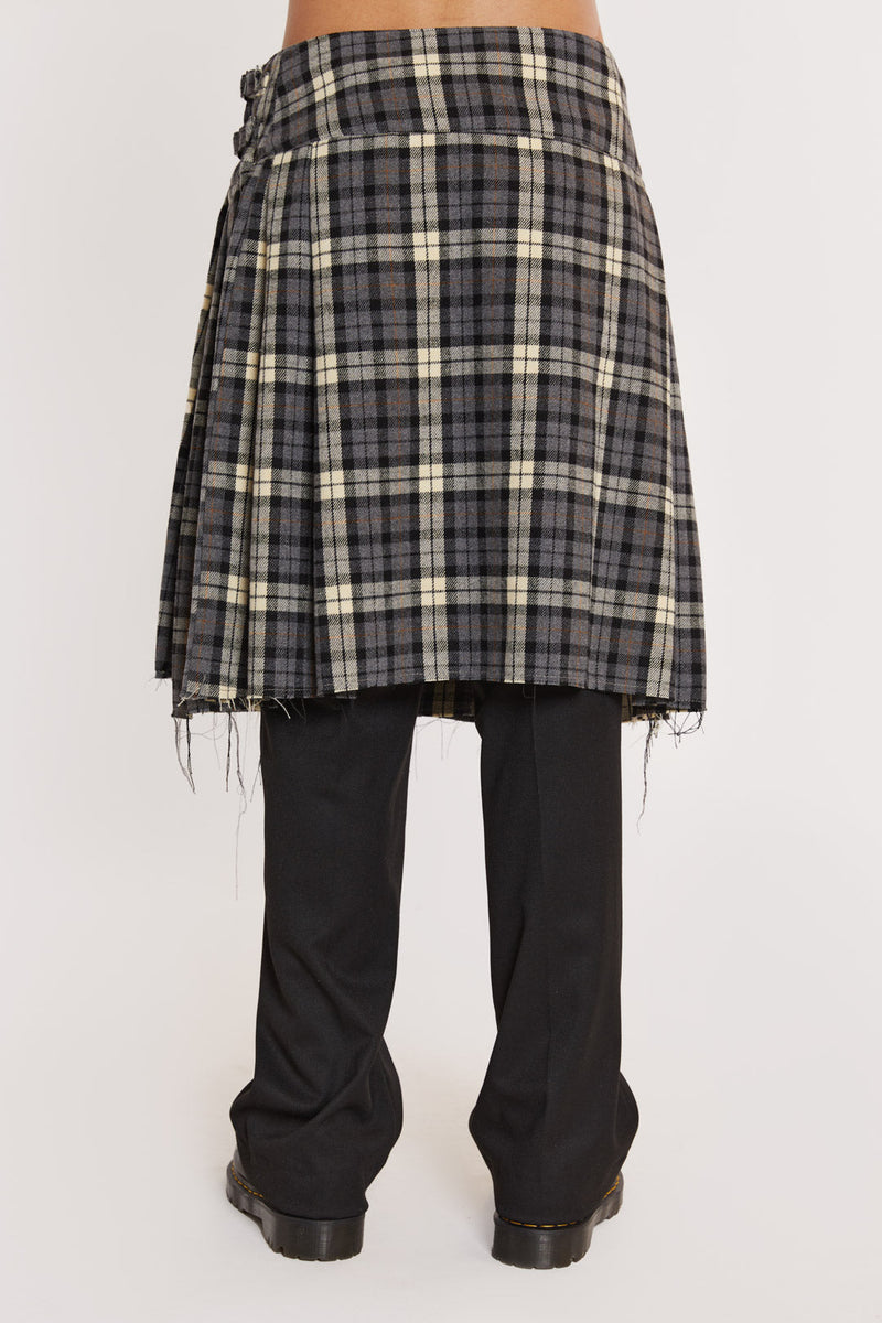 Male wearing Grey Checked Kilt. Styled with black suit trousers and white shirt. 