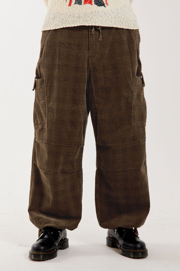 Male wearing oversized brown check military style cargo pants.