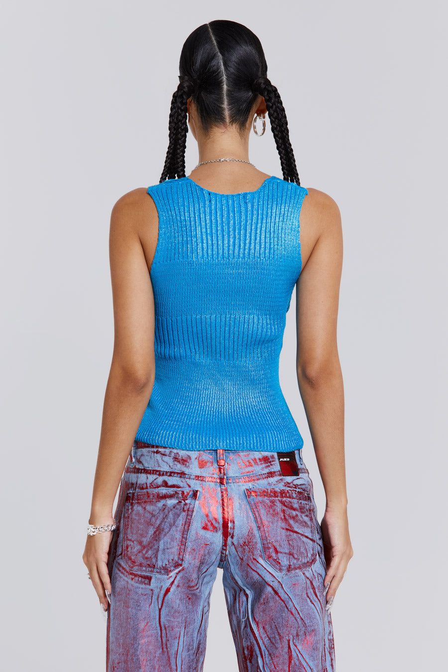 Female wearing blue metallic knitted v-neck sliced top. Styled with blue and red metallic distressed jeans. 