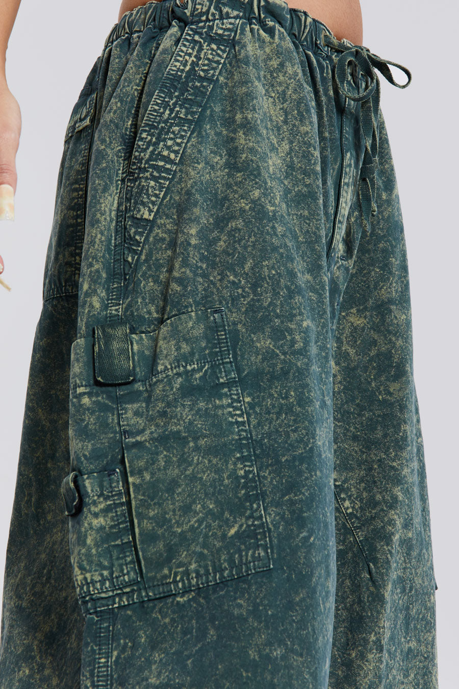 Female wearing green acid wash parachute cargo pants. 