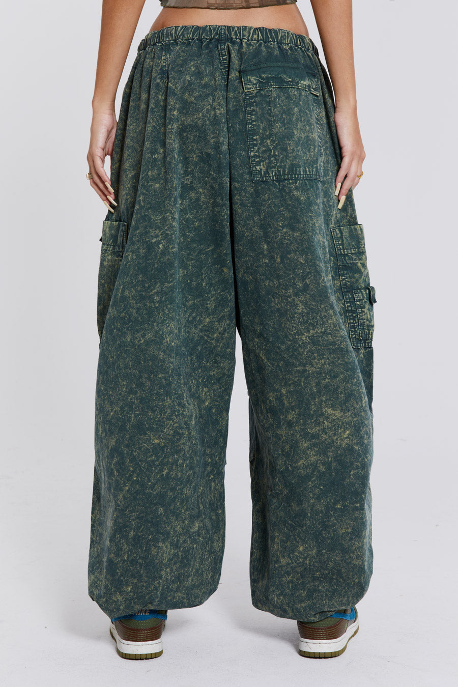 Female wearing green acid wash parachute cargo pants. 