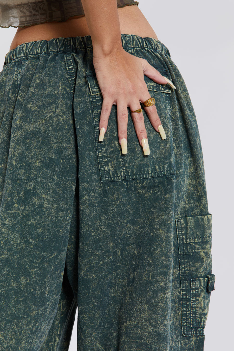 Female wearing green acid wash parachute cargo pants. 