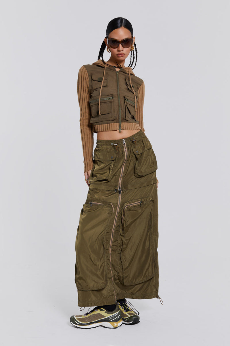 Female wearing a shiny khaki green pocket detail cargo midi skirt. Styled with a khaki green cargo jacket. 