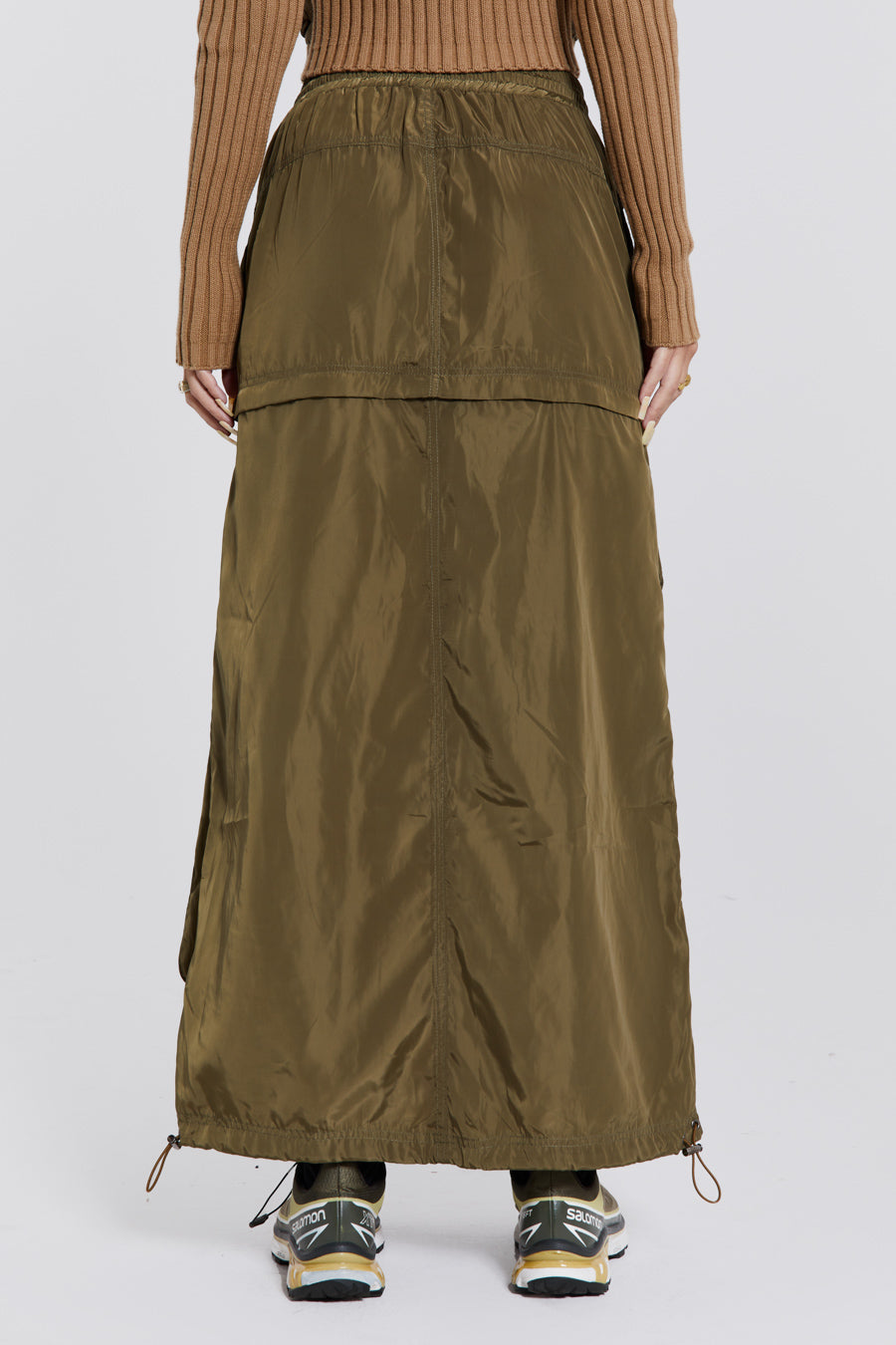 Female wearing a shiny khaki green pocket detail cargo midi skirt. Styled with a khaki green cargo jacket. 