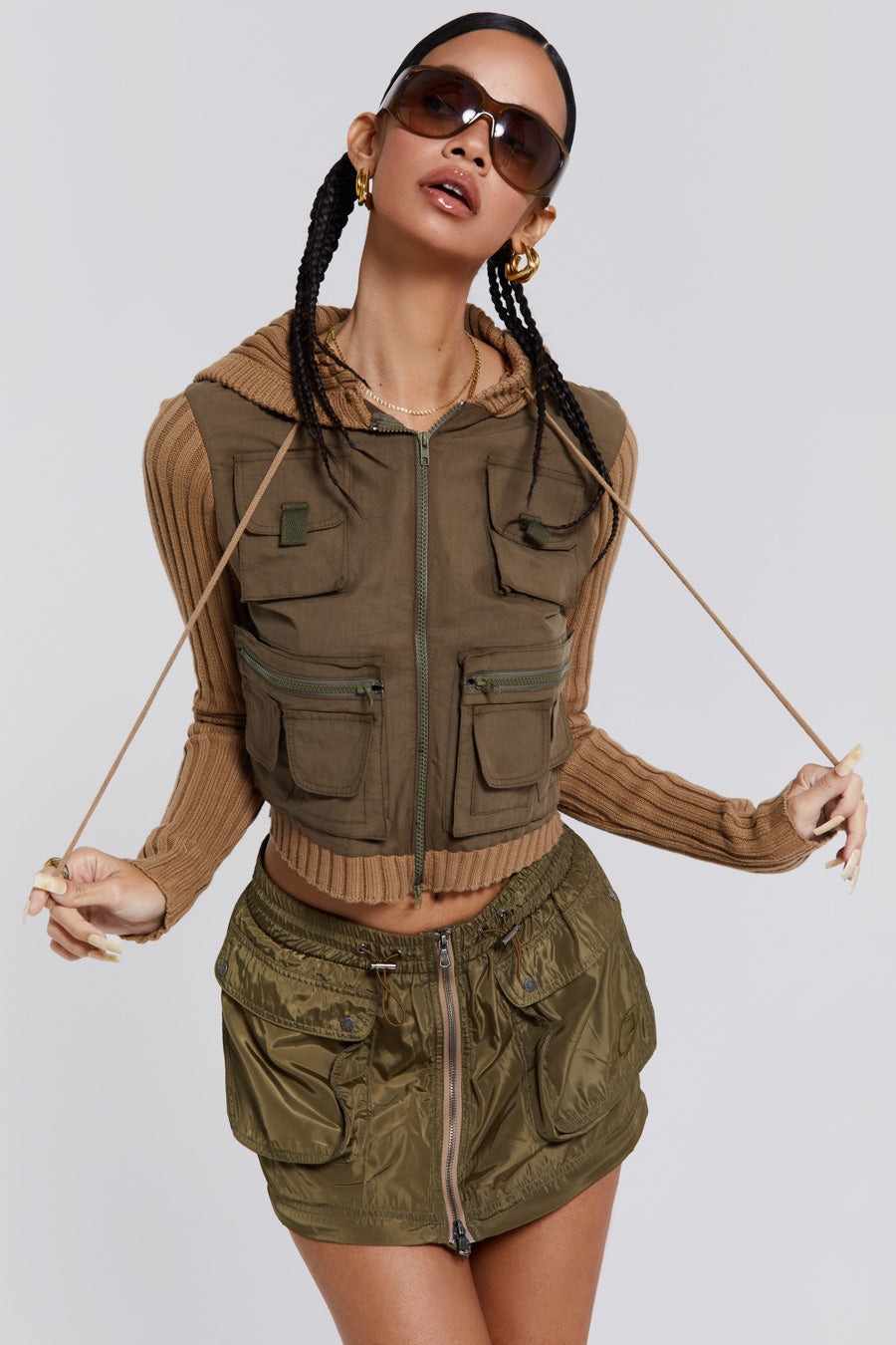 Female wearing a shiny khaki green pocket detail zip off cargo mini skirt. Styled with a khaki green cargo jacket. 