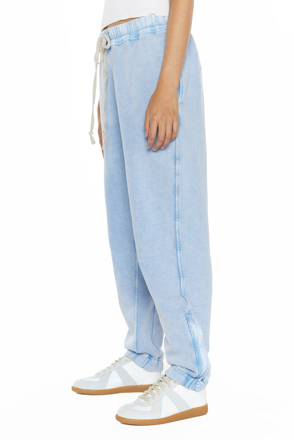 Powder blue cuffed joggers, styled with a white vest top. 