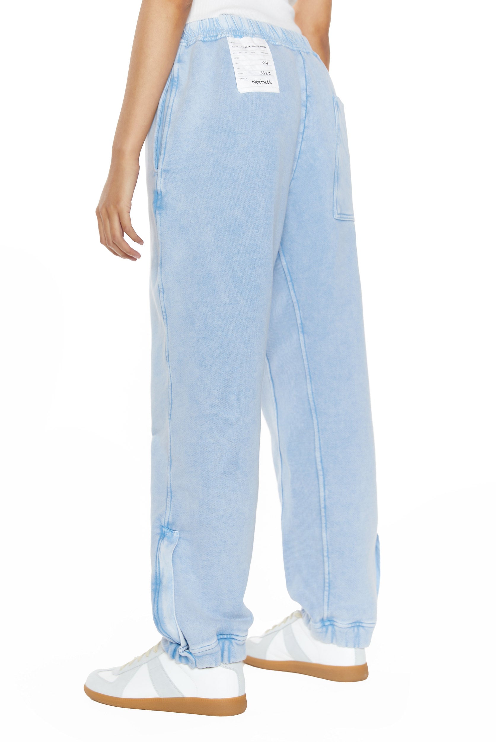 Powder blue cuffed joggers, styled with a white vest top. 