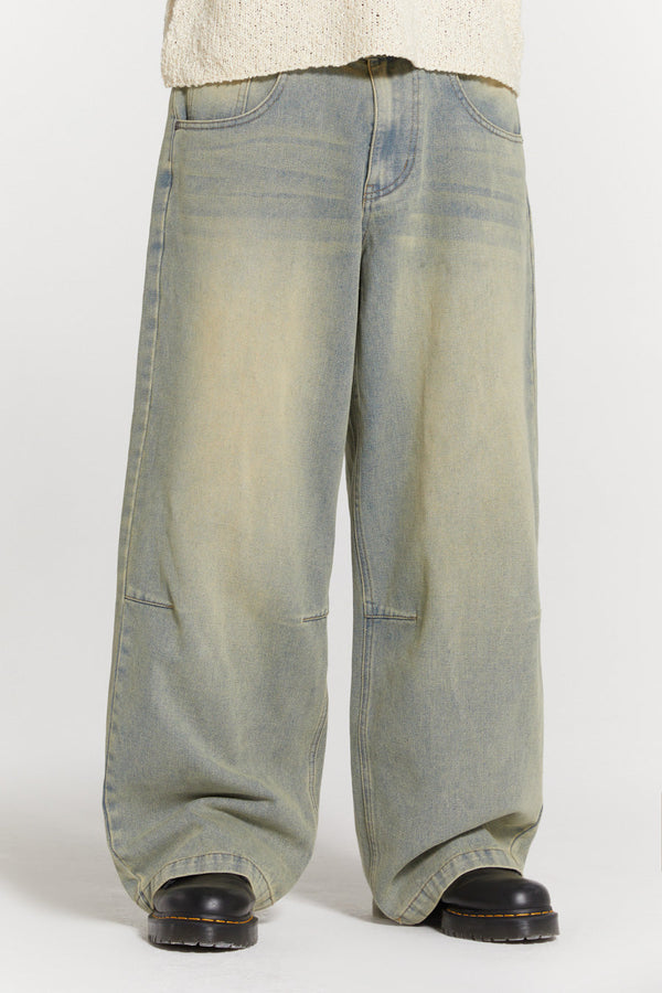 Male wearing blue light wash colossus fit jeans. 